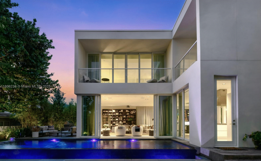 Luxury single-family residence at Ritz-Carlton Miami Beach with private pool, modern glass facade, and outdoor living spaces at twilight