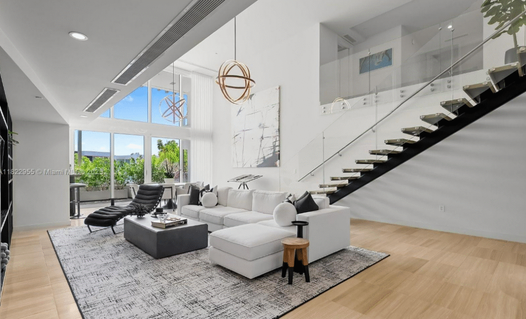 Luxury Ritz-Carlton Miami Beach residence interior with open-concept living space, floating staircase, panoramic windows, and high-end modern furnishings